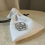The Isla Ring  stacking rings with mother-of-pearl heart and stone detail, laid on The Seventh Edit’s branded white pouch.