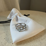 The Isla Ring  stacking rings with mother-of-pearl heart and stone detail, laid on The Seventh Edit’s branded white pouch.
